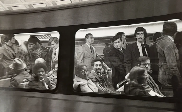 A diverse group of commuters inside a Washington DC Metro train during its early years, showcasing different fashion styles and expressions, reflecting the vibrancy of city life. The image captures a moment in the history of the Metro system, emphasizing community and daily transit experiences.