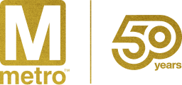 Metro logo featuring a stylized "M" in gold on the left side, with "metro" below it. On the right, the text "50 years" in a modern, bold font, also in gold, celebrating the 50th anniversary of the Washington DC Metro system. The background is black, enhancing the visibility of the gold elements.