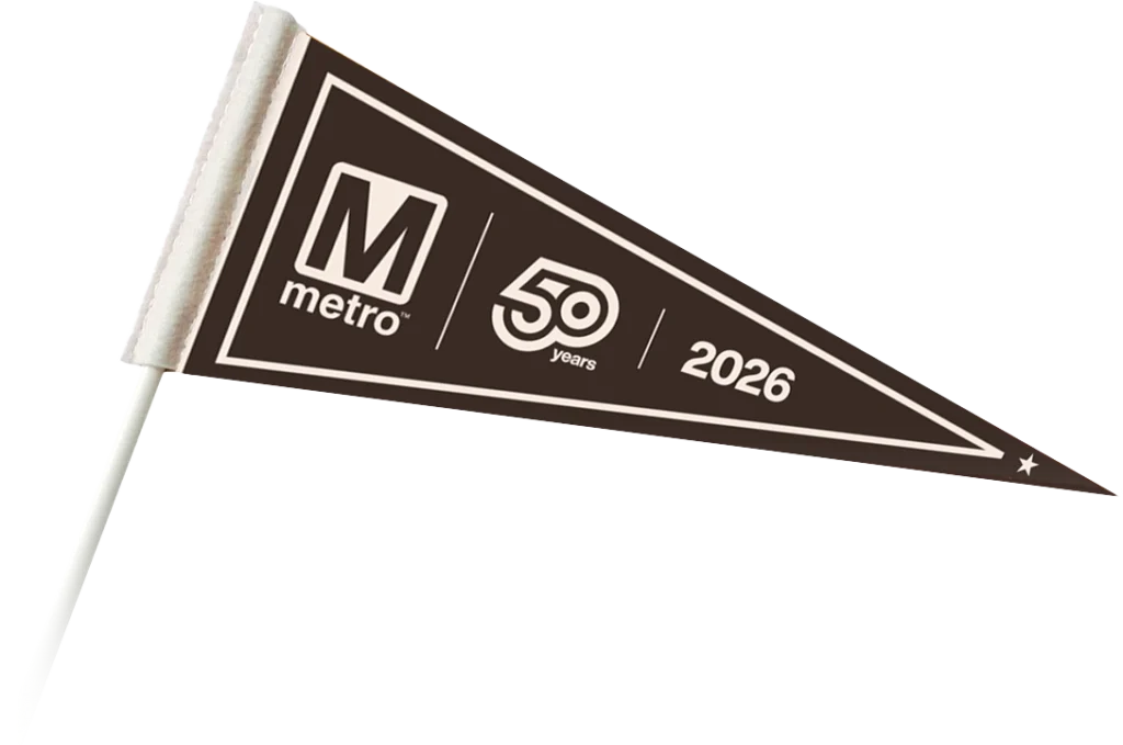 A triangular pennant featuring the Metro logo, text celebrating "50 years" in a bold font, and the year "2026," all against a dark background. The design highlights the 50th anniversary of the Metro system in the Washington DC region.